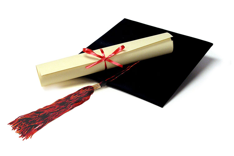 graduation cap with a rolled degree atop of it