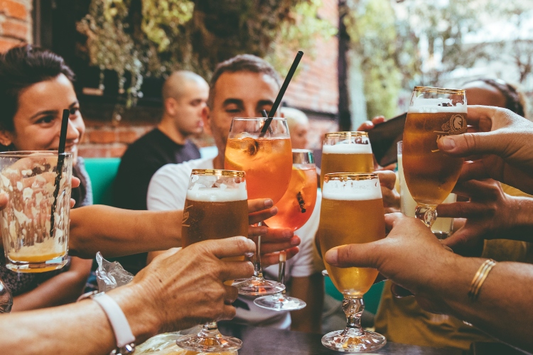 people raising their drinks in cheers