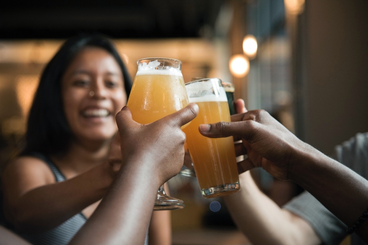 people holding up a beer in cheers